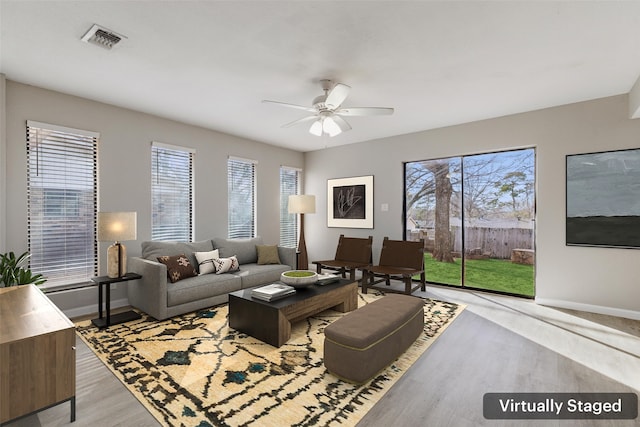 living room with plenty of natural light, light hardwood / wood-style floors, and ceiling fan