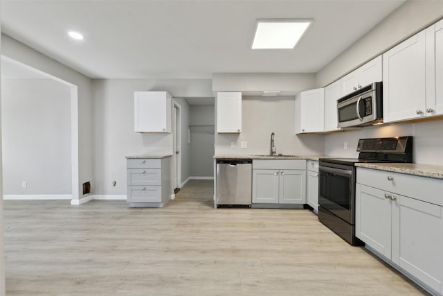 kitchen featuring white cabinetry, stainless steel appliances, light hardwood / wood-style floors, and sink