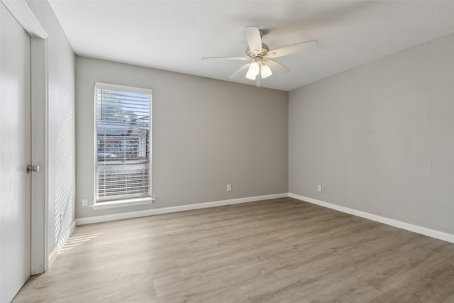 spare room with ceiling fan and light wood-type flooring