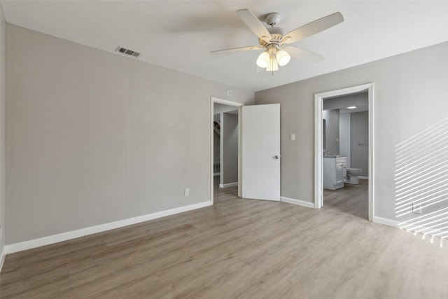 unfurnished bedroom with hardwood / wood-style flooring, ceiling fan, and connected bathroom