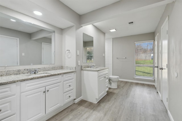 bathroom with vanity, toilet, and hardwood / wood-style floors