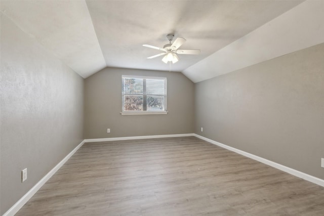 additional living space with ceiling fan, vaulted ceiling, and light wood-type flooring