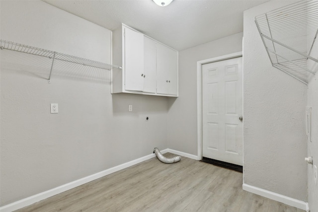 washroom with cabinets, hookup for an electric dryer, and light wood-type flooring