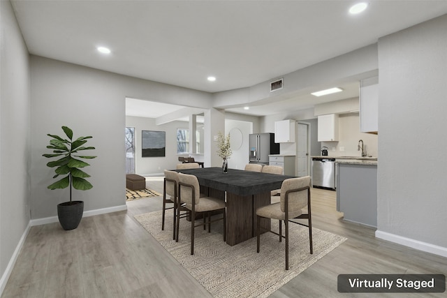 dining area featuring sink and light wood-type flooring