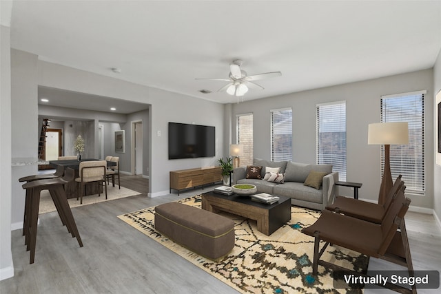 living room featuring light hardwood / wood-style flooring and ceiling fan