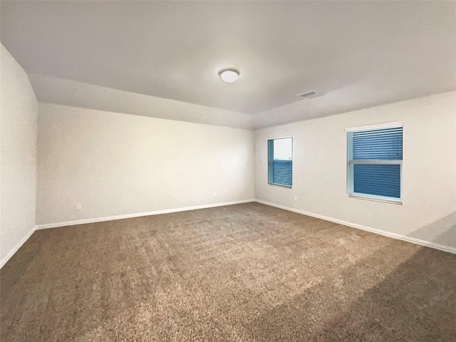 unfurnished room with dark colored carpet