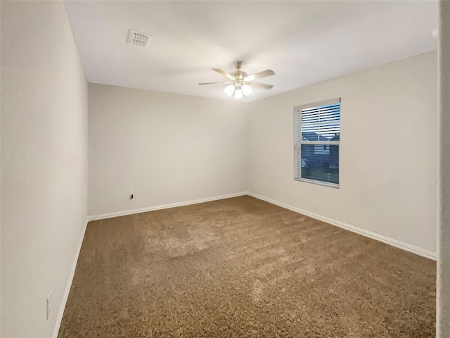 empty room with ceiling fan and dark colored carpet