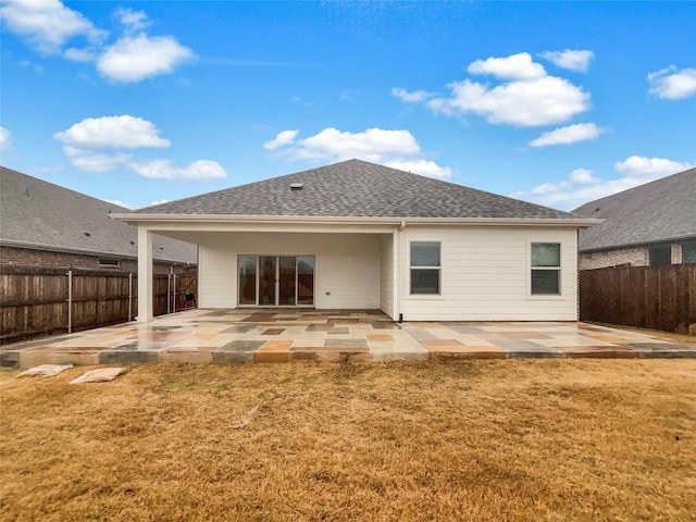 rear view of house with a yard and a patio