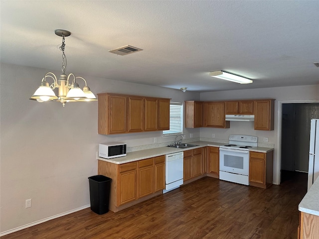 kitchen featuring sink, pendant lighting, white appliances, and dark wood-type flooring