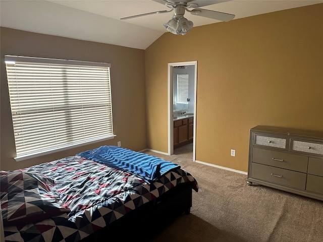 bedroom with ceiling fan, light colored carpet, lofted ceiling, and connected bathroom