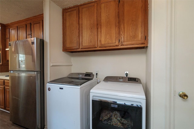 laundry area featuring washing machine and clothes dryer and a textured ceiling
