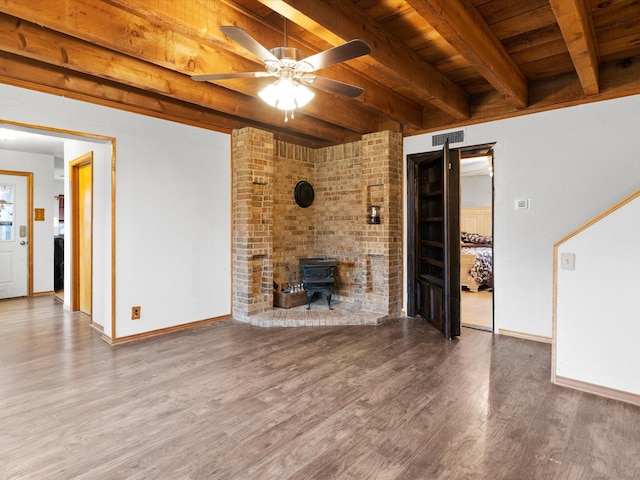 unfurnished living room with hardwood / wood-style flooring, wooden ceiling, beam ceiling, and a wood stove