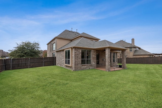 rear view of house featuring a yard and a patio area