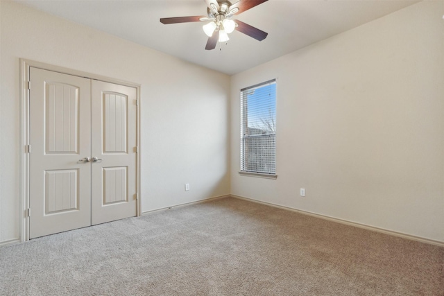 spare room featuring light carpet and ceiling fan