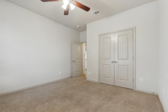 unfurnished bedroom with light colored carpet, ceiling fan, and a closet