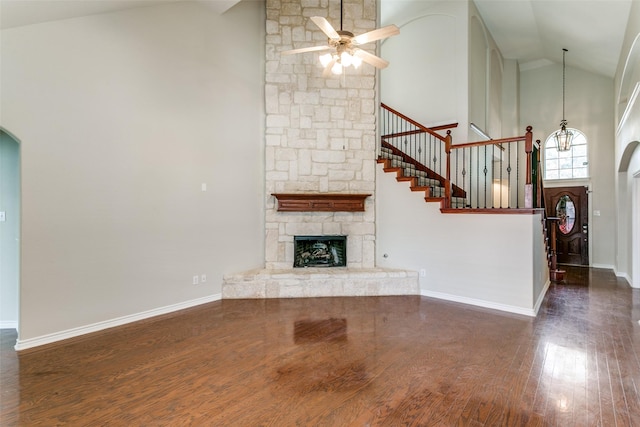 unfurnished living room featuring a fireplace, dark wood-type flooring, high vaulted ceiling, and ceiling fan