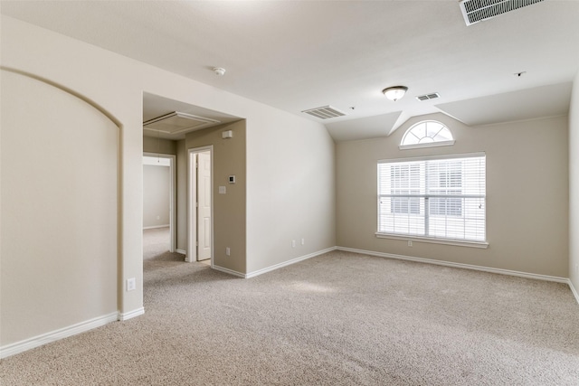 spare room with vaulted ceiling and light colored carpet