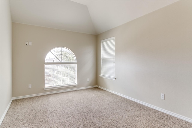 empty room with lofted ceiling and carpet flooring