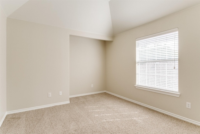 spare room with carpet flooring and vaulted ceiling