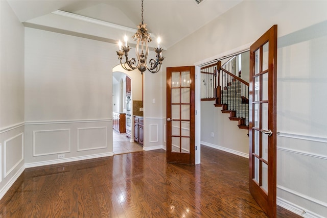 interior space featuring an inviting chandelier, lofted ceiling, hardwood / wood-style floors, and french doors