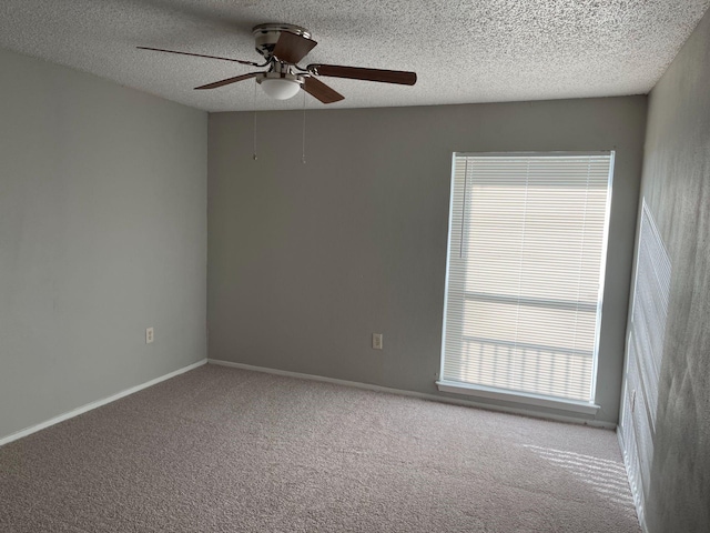 carpeted empty room with ceiling fan and a textured ceiling