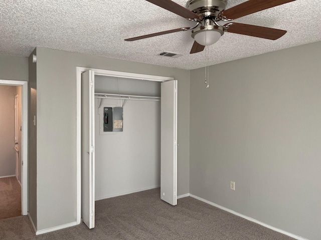 unfurnished bedroom featuring carpet flooring, electric panel, ceiling fan, a textured ceiling, and a closet