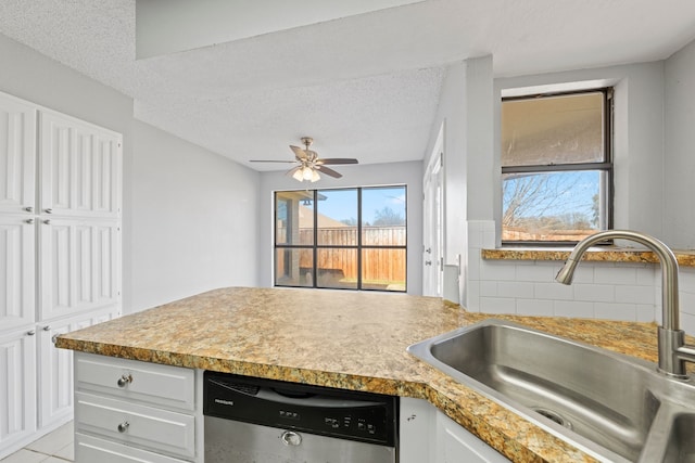 kitchen featuring white cabinetry, stainless steel dishwasher, a healthy amount of sunlight, and sink