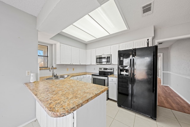 kitchen with sink, stainless steel appliances, white cabinets, light tile patterned flooring, and kitchen peninsula