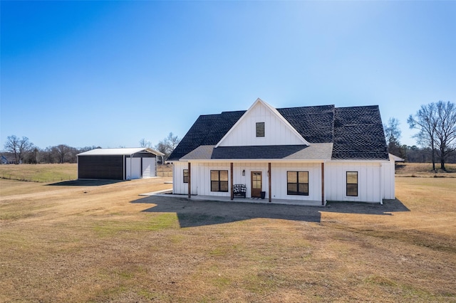 modern farmhouse with a garage, an outbuilding, covered porch, and a front lawn