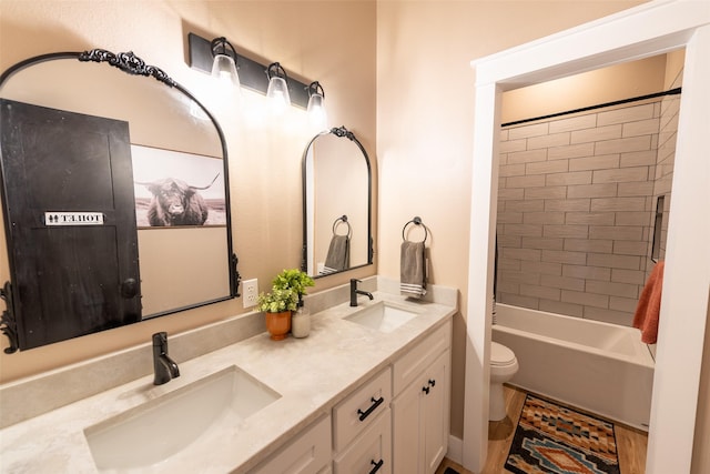 full bathroom with vanity, tiled shower / bath, and toilet