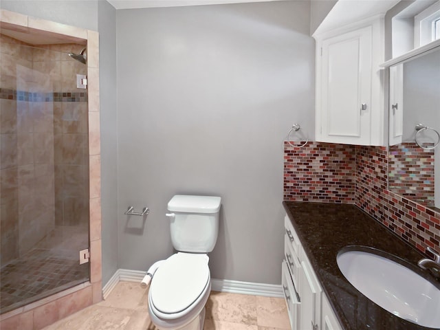 bathroom featuring tasteful backsplash, vanity, toilet, and a shower with door