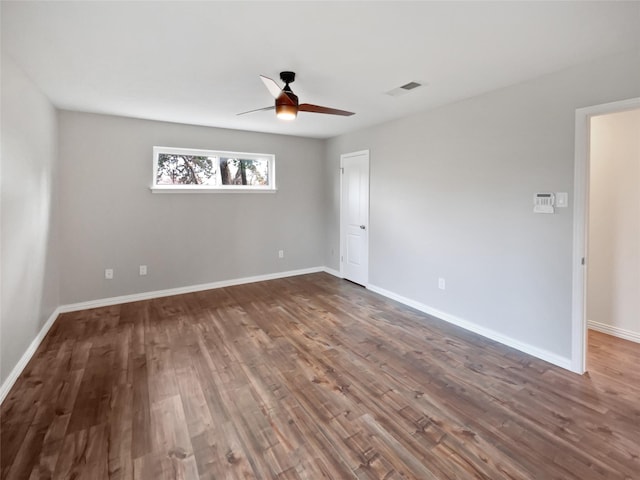 unfurnished room featuring dark wood-type flooring and ceiling fan