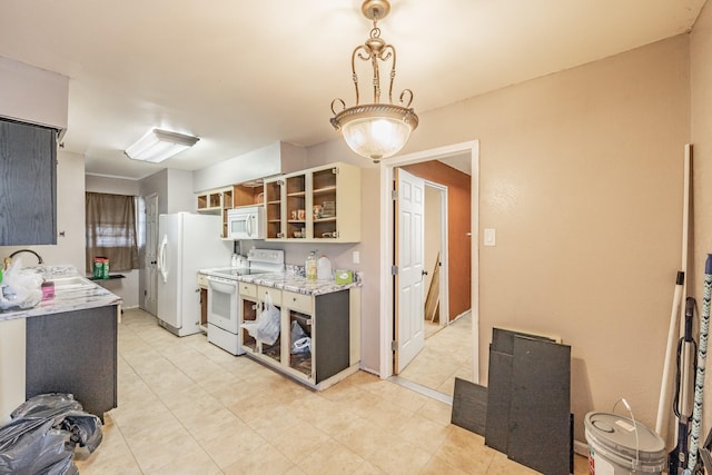 kitchen with white appliances, light stone countertops, sink, and light tile patterned floors