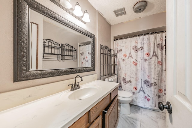 bathroom featuring vanity, toilet, and a textured ceiling