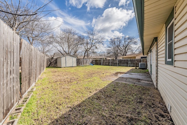 view of yard featuring a storage shed and central AC unit