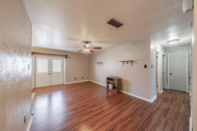 empty room with dark wood-type flooring, french doors, and ceiling fan