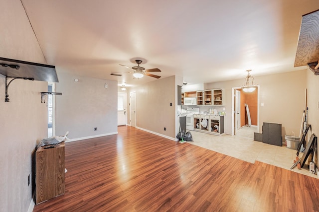 unfurnished living room with ceiling fan and light hardwood / wood-style flooring