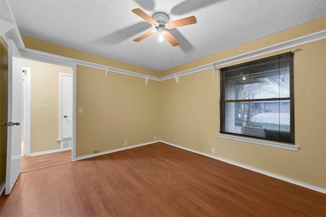 spare room with wood-type flooring, ceiling fan, and a textured ceiling