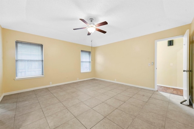 tiled empty room featuring ceiling fan