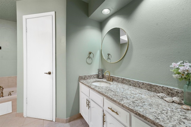 bathroom with a relaxing tiled tub, tile patterned floors, and vanity