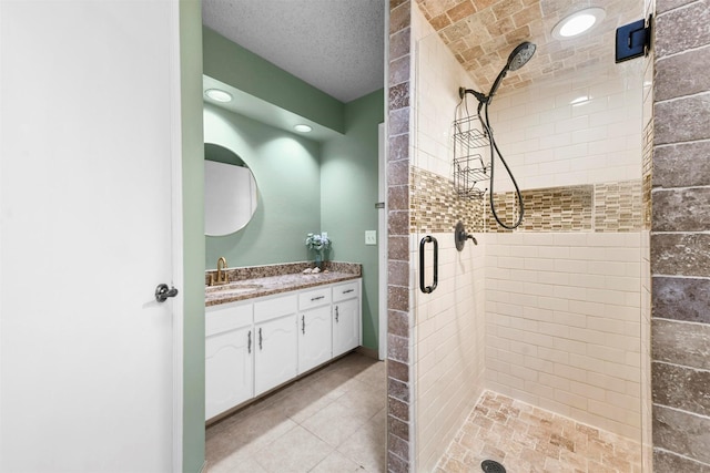 bathroom with a shower with door, vanity, and a textured ceiling