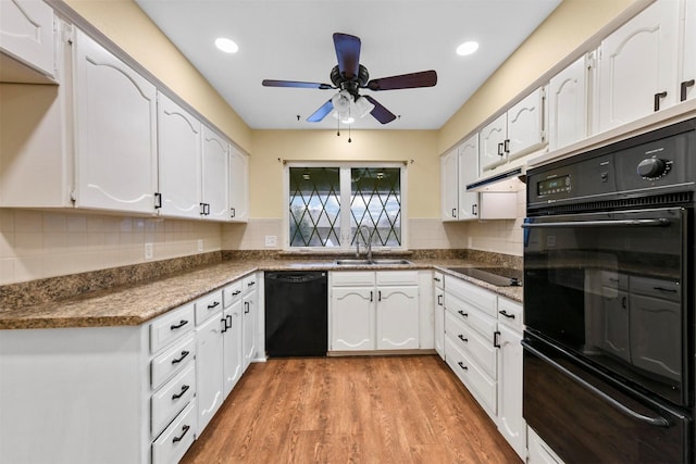 kitchen featuring white cabinetry, sink, decorative backsplash, black appliances, and light wood-type flooring