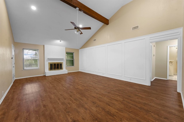 unfurnished living room with ceiling fan, a brick fireplace, dark hardwood / wood-style floors, and beam ceiling