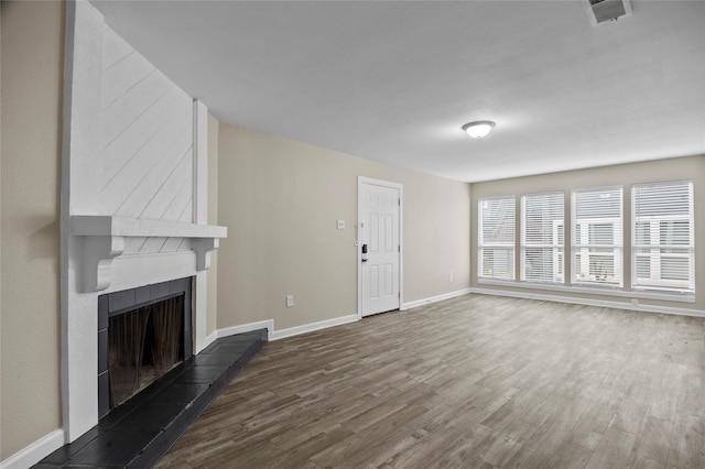 unfurnished living room featuring a fireplace and dark hardwood / wood-style floors