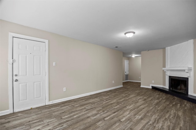 unfurnished living room featuring a large fireplace and hardwood / wood-style floors