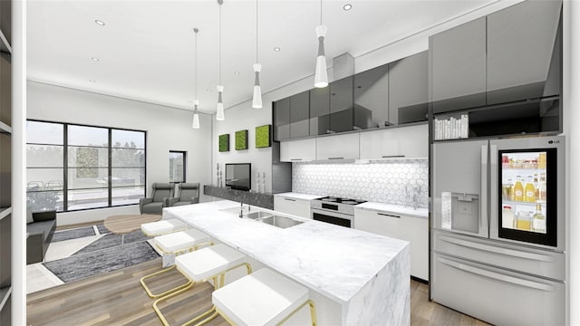 2080 Kelly Ave Unit 107, Dallas, TX 75215 - kitchen featuring sink, hanging light fixtures, refrigerator with ice dispenser, a kitchen island with sink, and white cabinets