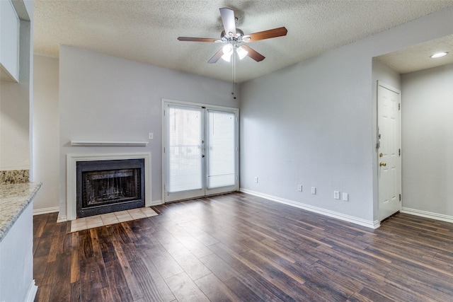 unfurnished living room with ceiling fan, dark hardwood / wood-style floors, and a textured ceiling