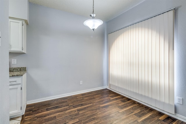 unfurnished dining area featuring dark hardwood / wood-style flooring