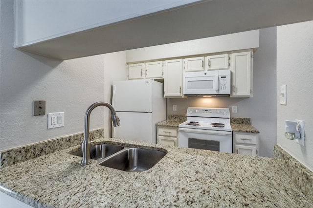 kitchen featuring sink, white appliances, white cabinetry, light stone countertops, and kitchen peninsula