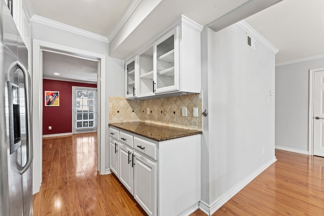 kitchen with white cabinetry, stainless steel refrigerator with ice dispenser, ornamental molding, and light wood-type flooring